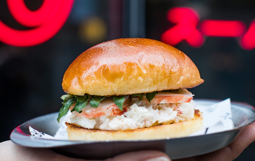 A lobster roll being held up.